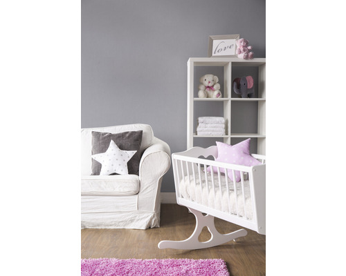 Kinderzimmer mit weißem Sofa, Regal und Wiege