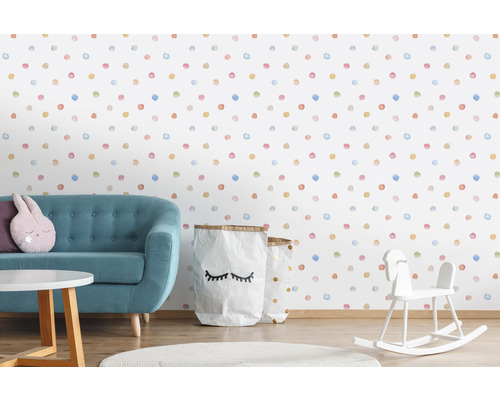 Dekorativer Kinderzimmerbereich mit Sofa, Spielzeug und Tapete mit Punktmuster