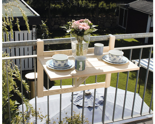 Balkontisch aus Holz mit Blumenvase und Geschirr auf einem Balkon
