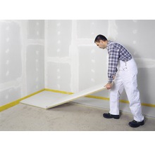 Mann verlegt Trockenbauplatten in einem Raum.