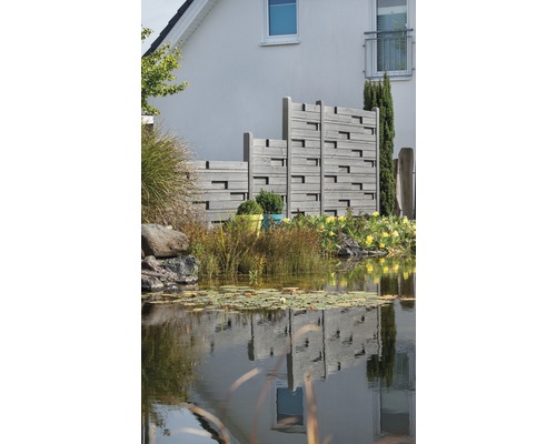 Gartenlandschaft mit Teich und Sichtschutzzaun aus Holz vor einem Haus