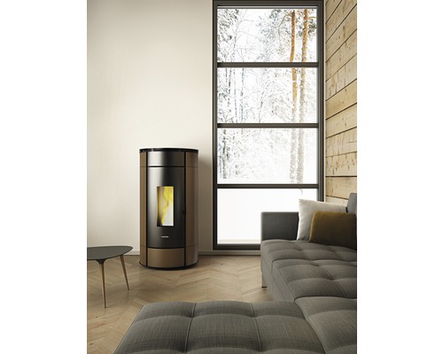 Wohnraum mit Pelletofen, Sofa und großem Fenster mit Winterlandschaft