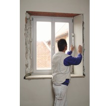 Ein Mann montiert eine Fensterverkleidung mit einer Wasserwaage.