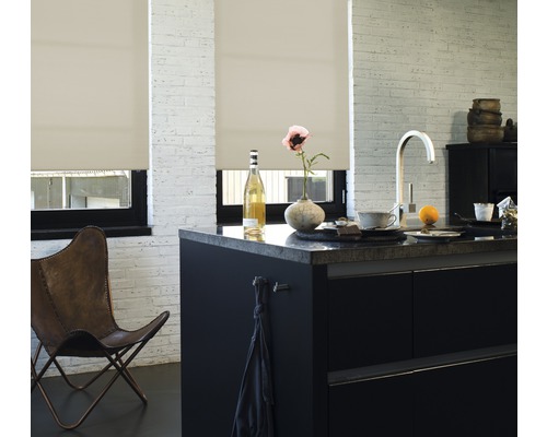 Helle Küche mit Rollos vor den Fenstern, einer Kücheninsel und einem Lederstuhl.