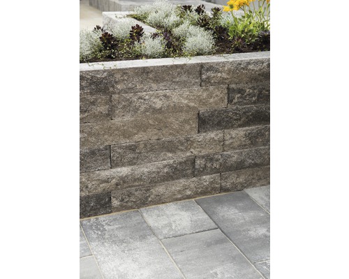 Mauer aus Betonsteinen mit Blumen bepflanzt