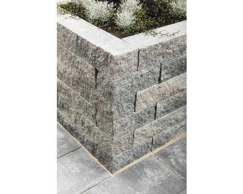 Eckansicht einer Gartenmauer aus Stein mit Bepflanzung