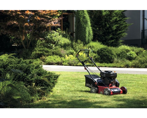 Rasenmäher auf Rasenfläche im Garten