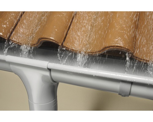 Regenwasser fließt vom Dach in eine Kunststoff Dachrinne.