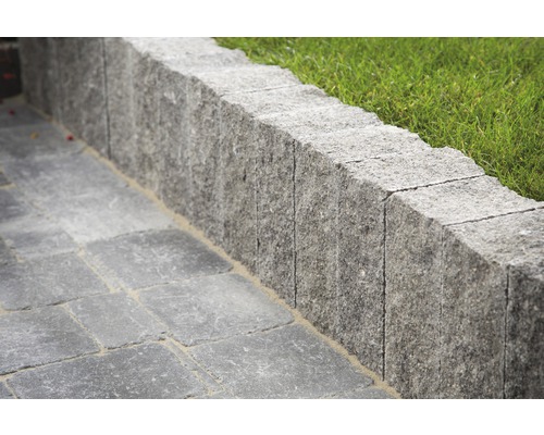 Steinmauer mit Pflastersteinen und Gras