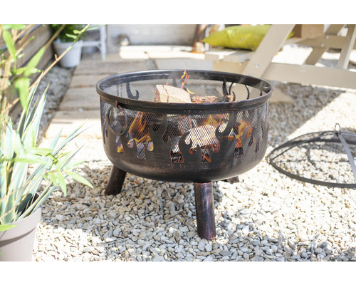 Feuerstelle mit Flammenmuster und Funkenschutzgitter im Garten.