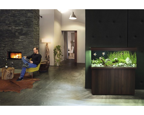 Wohnzimmer mit Kamin, Lesesessel und Aquarium