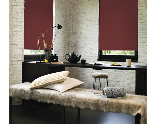 Helles Zimmer mit Fensterrollos, Tisch, Lampe, Kissen und Dekorationsartikeln für eine gemütliche Atmosphäre