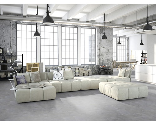 Helles Wohnzimmer im Loftstil mit modularem Sofa, Betonwand und großen Fenstern.
