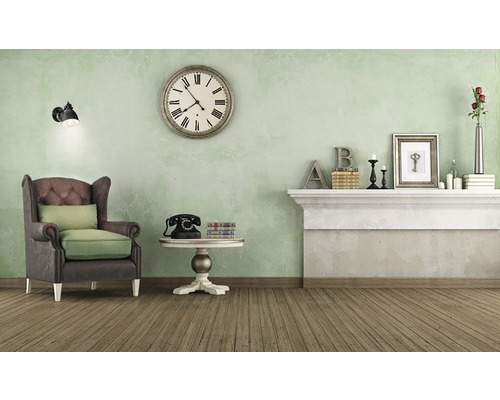 Interieuransicht eines Wohnzimmers mit Sessel, Tisch, Kamin und Dekoration