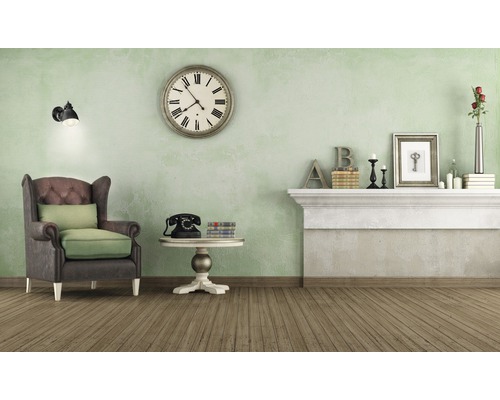 Wohnzimmer mit Sessel, Uhr und Dekoration auf dem Kaminsims