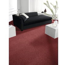 Innenraum mit rotem Teppich, schwarzem Sofa und weißen Beistelltischen.