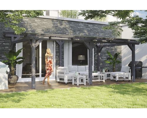 Terrassenüberdachung SKAN HOLZ Siena 648x250 cm schiefergrau Holzpergola mit Sitzgruppe auf einer Terrasse in einem Garten.