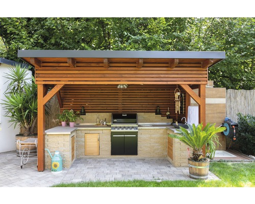 Überdachte Outdoor-Küche mit Grill und Arbeitsflächen im Garten.