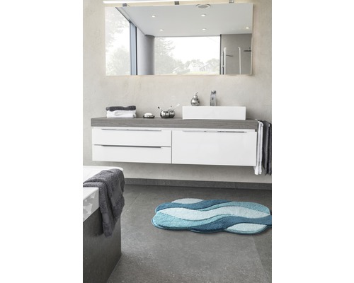 Badezimmer mit Waschtisch, Spiegel und blauer Badematte