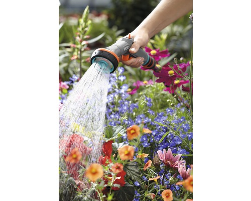 Eine Person bewässert Blumen mit einer Gardena-Gartenspritze.