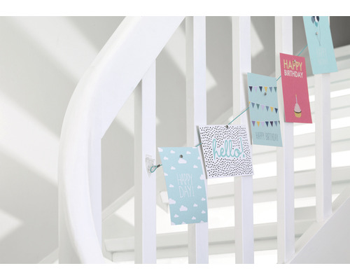 Dekorative Grußkarten hängen an einem Treppengeländer und sind mit Botschaften verziert.