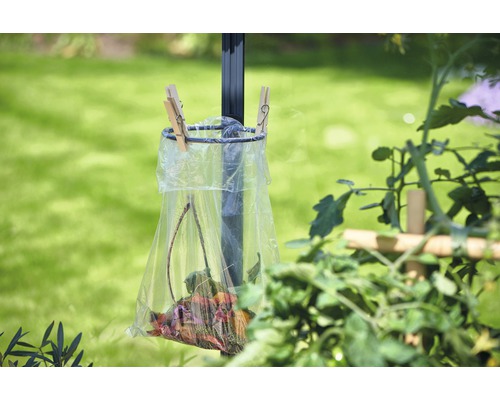 Abfallbehälter mit Blättern, an einer Stange befestigt, im Garten