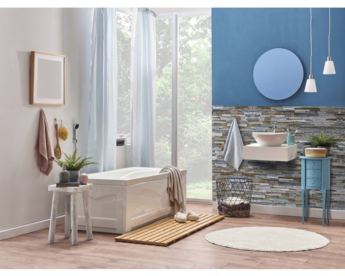 Badezimmer mit Badewanne, Waschbecken, Spiegel und Dekorationen für eine entspannende Atmosphäre