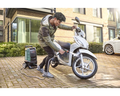 Eine Person reinigt einen Roller mit einem Hochdruckreiniger von Bosch.