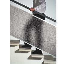 Mann trägt Dämmplatte die Treppe hoch.