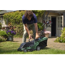Ein Mann benutzt einen Bosch Rasenmäher im Garten.