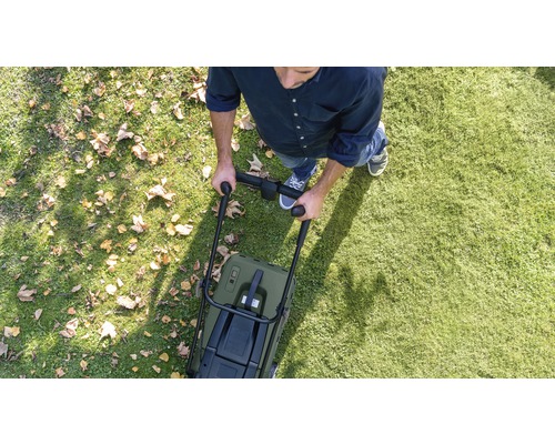 Mann mäht Rasen mit einem Rasenmäher