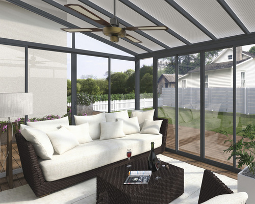 Veranda mit Sitzgruppe, Deckenventilator und Blick in den Garten.