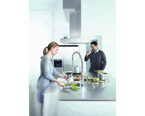 Moderne Küche mit Dunstabzugshaube, Spültischarmatur und zwei Personen beim Kochen