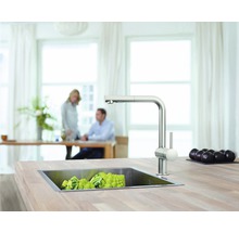 Küchenszene mit Spüle, Armatur und Gemüse auf einer Arbeitsplatte