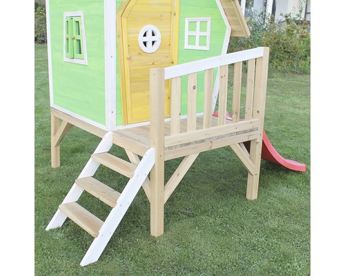 Spielhaus mit Treppe und Rutsche im Garten.
