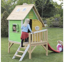 Spielhaus aus Holz mit Rutsche im Garten mit spielenden Kindern.
