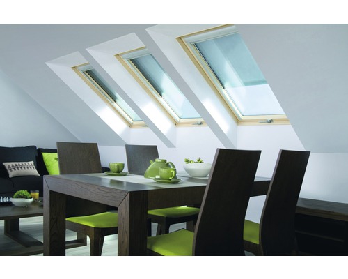 Wohnzimmer mit Dachfenstern, Esstisch und Sitzgelegenheiten in einem hellen Dachgeschoss