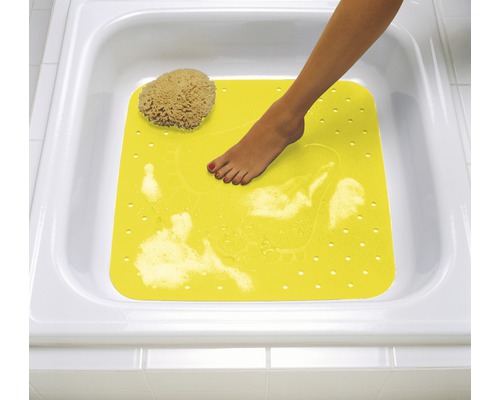 Gelbe Badewannenmatte mit Fuß in einer weißen Badewanne