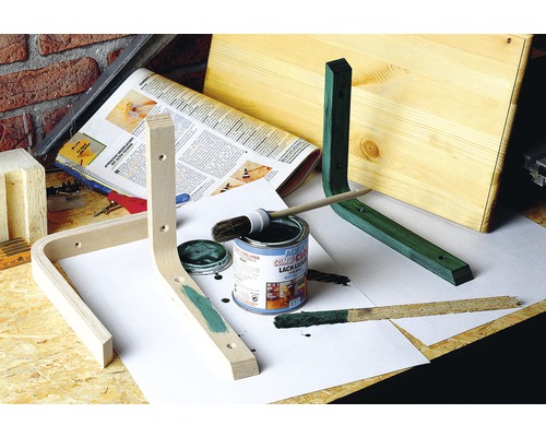 Werkstattszenenbild mit Holzwerkstücken, Farbdose, Pinsel und Anstrich