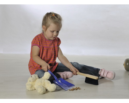 Mädchen kehrt mit Kehrschaufel und Besen