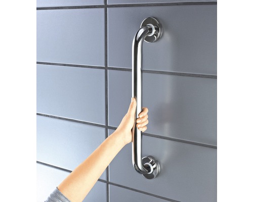 Person hält einen an der Wand montierten Haltegriff aus Metall.