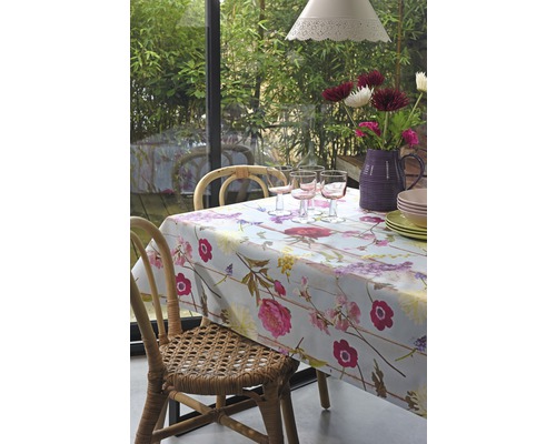 Esstisch mit Blumendecke, Gläsern, Geschirr und Blumenstrauß in Vase