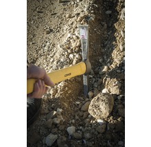 Hand hält Fäustel zum Bearbeiten von Erdreich mit Steinen