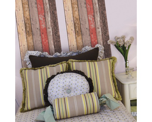 Dekoratives Bett mit gemusterten Kissen, einschließlich gestreifter, gepunkteter und runder Kissen