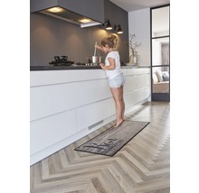 Küche mit Küchenläufer im Holzdesign und jungem Mädchen am Herd