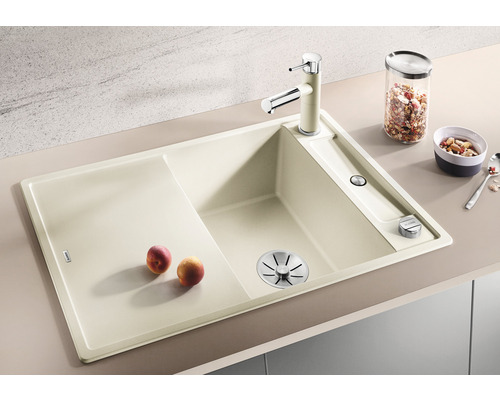 Beige Küchenspüle mit Abtropffläche, Armatur und Spülmittelspender.