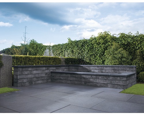 Außenbereich mit Pflastersteinen und Gartenbank aus Stein