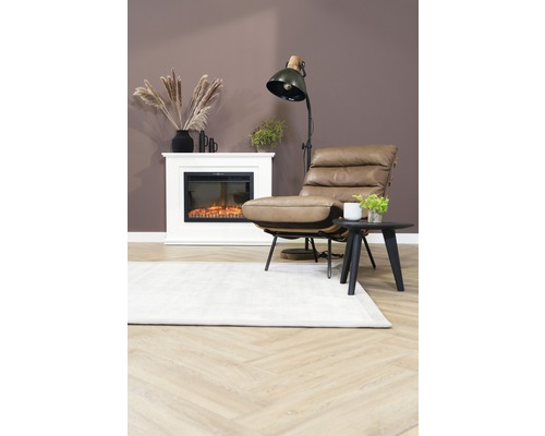 Wohnzimmer mit Sessel, Stehlampe, Kamin und Teppich auf Holzboden