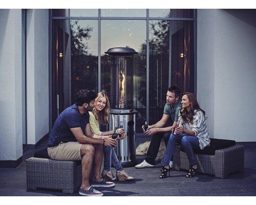 Gruppe von Personen sitzt um einen Terrassenheizer im Freien.