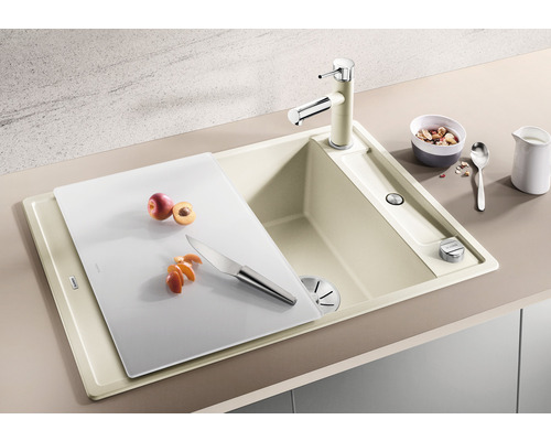 Spüle mit Schneidebrett, Wasserhahn, Obst und Messer auf einer Küchenarbeitsplatte